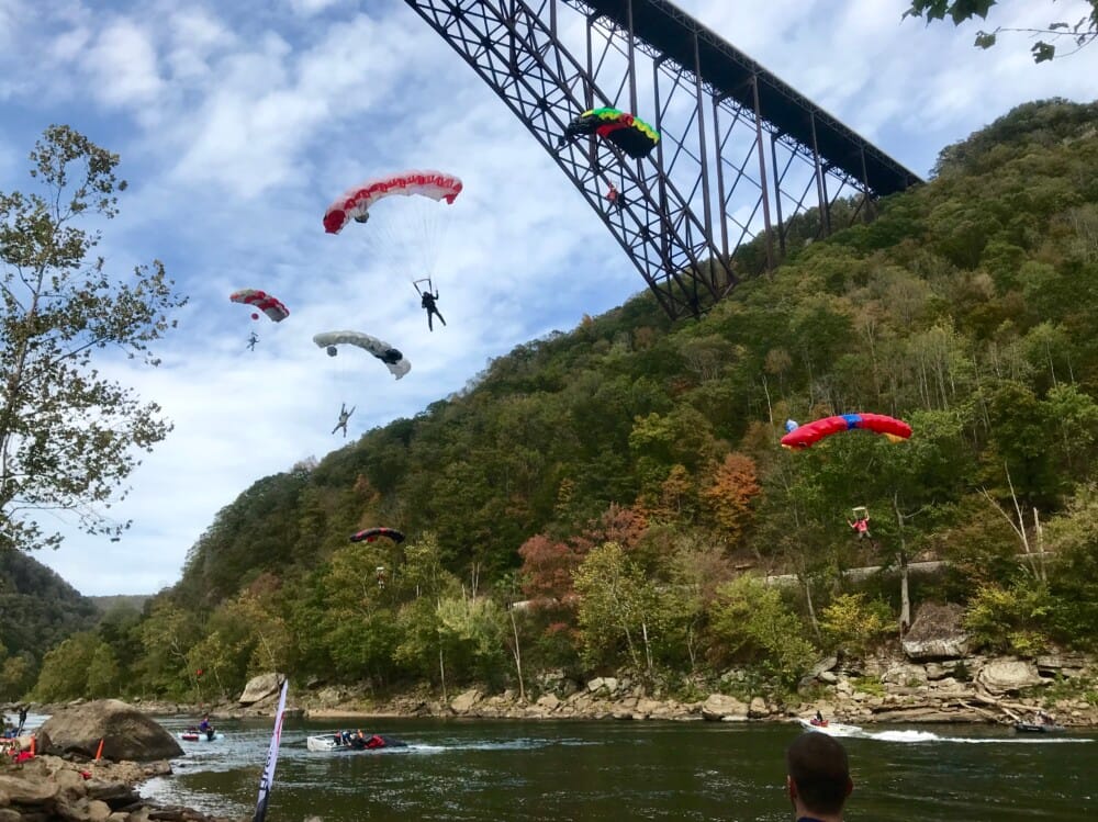 BASE jumper with parachute leaping from the New River Gorge Bridge during Bridge Day festival in Fayetteville, West Virginia.